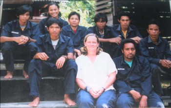 Photographic Memories: Pak Ateng (top row, far right with a yellow shirt showing under his uniform) back when he first started working at the OFI Care Center. (Western visitor is in center).